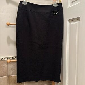 Black pencil skirt. Woven ribbed fabric. Back slit.